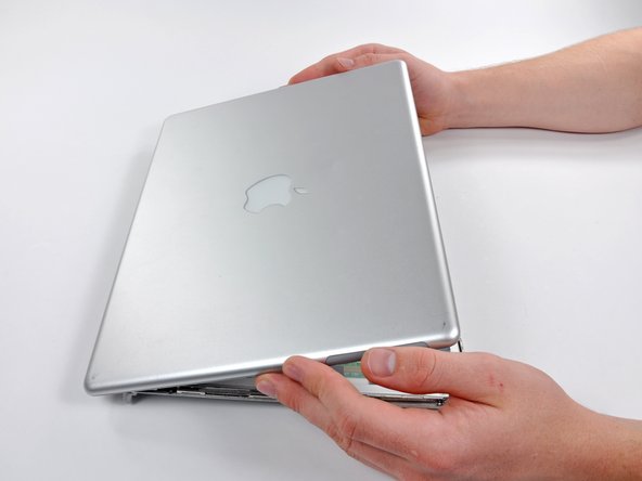 Image 3/3: The rear bezel is still connected to the display via ribbon cables on the botom edge.