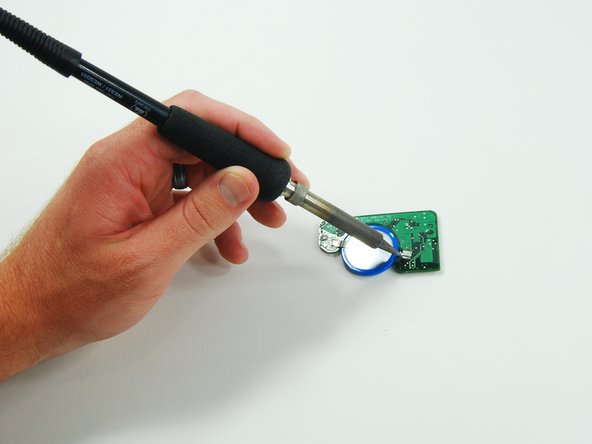 Image 1/2: Using the soldering iron, apply pressure until the solder liquefies and joins with the battery terminal