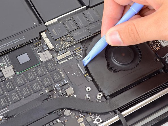 Image 2/2: Starting at the top of the cable, slide a plastic opening tool under the right fan cable to free it from the logic board.