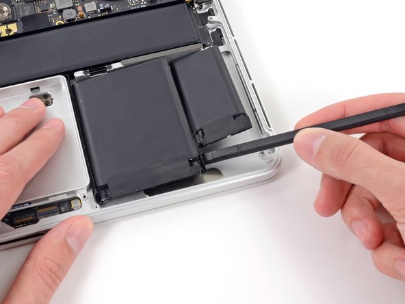 Image 1/1: Slightly pry the bottom right corner up off the upper case to release the adhesive.