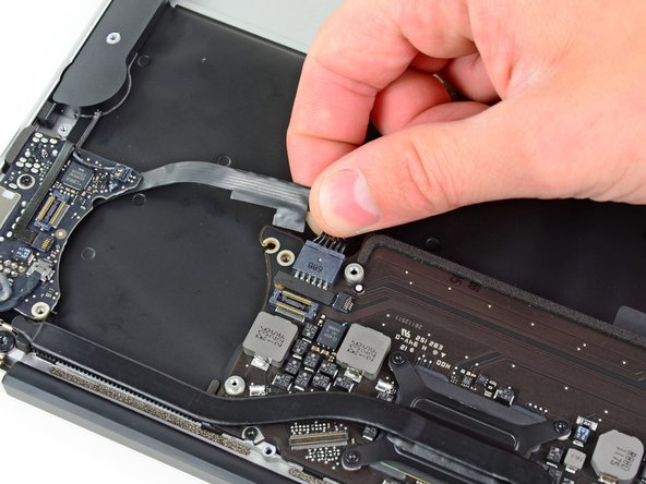Image 2/2: Pull the cable parallel to the face of the logic board toward the front edge of the Air.