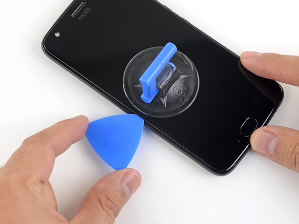 Slide the opening pick along the edge to slice through the adhesive.