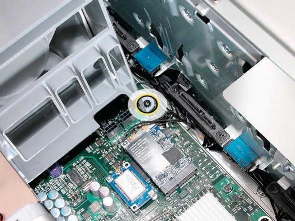 Image 2/3: Remove the second Phillips screw at the bottom front of the assembly.