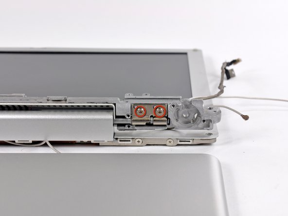 Image 2/2: Thread the display inverter, antenna, and display data cables through the bracket and remove the metal bracket.