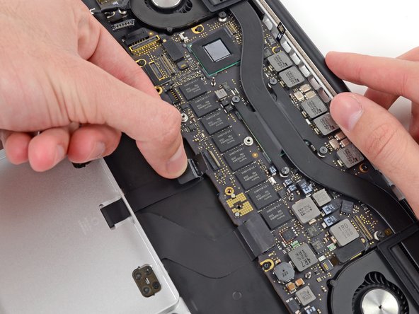 Image 2/2: Grasp the plastic pull tab and pull the trackpad ribbon cable out of its socket.