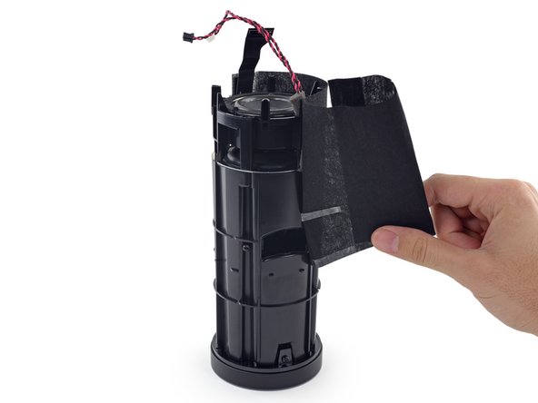 Image 3/3: It takes a skillful combination of knifery and peeling double-stick tape, but we eventually get the fabric off, exposing a [http://en.wikipedia.org/wiki/Pareidolia|sad-looking mouth|new_window=true] and the start of our path to a free motherboard.