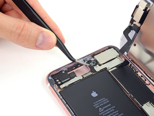 While supporting the display, use tweezers to begin peeling off the final release liners, exposing the adhesive.