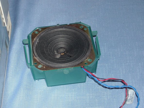 Image 3/3: Push in the two plastic tabs on either side and lift the speaker up and out.