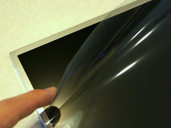 Image 3/3: A protective sheet is taped to the front of the display. Leave it on until we are almost done installing the display in the laptop.