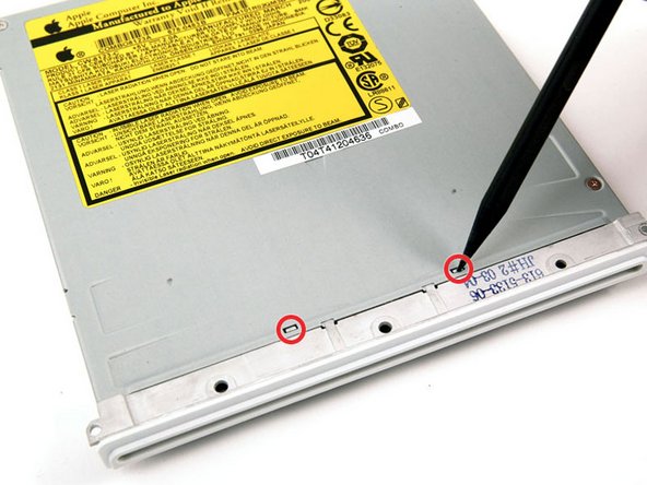 Image 1/1: Use a spudger to carefully depress the two tabs on top of the bezel.