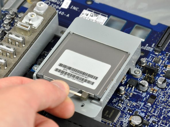 Image 1/1: This step does not apply to the ALS model; this bracket is not present. The card attaches with a pair of T6 Torx screws and looks slightly different from this picture.