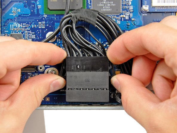 Image 1/2: After both locking arms pass their retaining tabs, it is helpful to push the arms toward the top edge of your iMac while wiggling the connector.