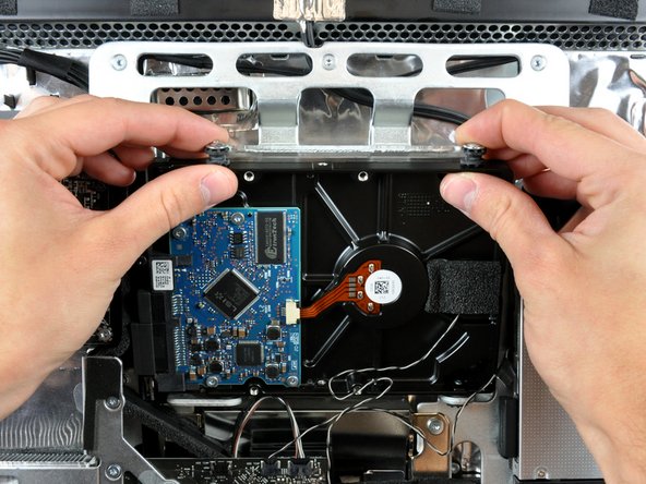 Rotate the top of the drive toward yourself, then lift the hard drive straight up off its lower pins.