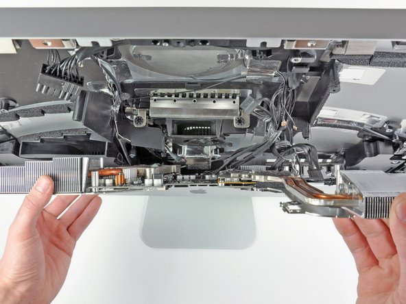 Image 2/2: If you want to remove the board, you have to snake it out from the rest of the iMac -- a combination of pulling up, as well as away from the casing. After a little bit of jiggling, it comes right out.