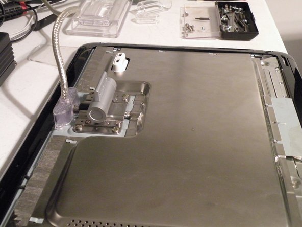 Image 1/3: After the tape and screw is removed, slide the panel towards you and lift it out.