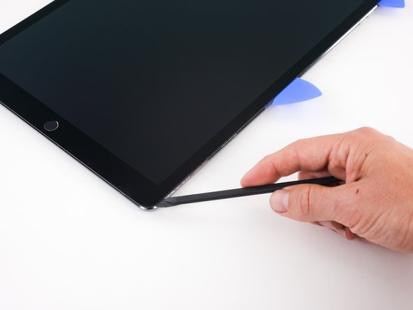Slide the halberd spudger down the side of the iPad to separate the adhesive.