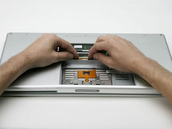 Image 1/1: Loosen the trackpad connector by pulling the locking bar toward the battery housing, using the tips of your fingers.