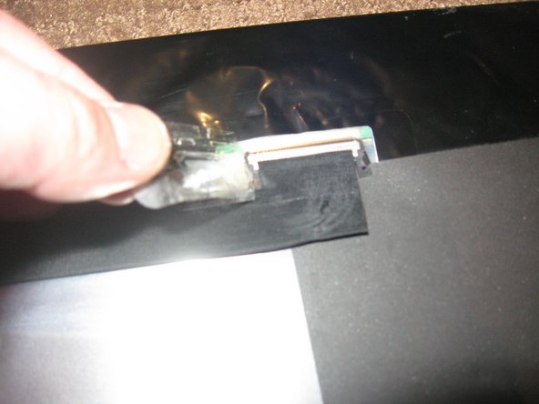 Image 1/2: Press '''IN''' the 2 silver spring loaded catches on either side to release the cable and gently extract it from the connector