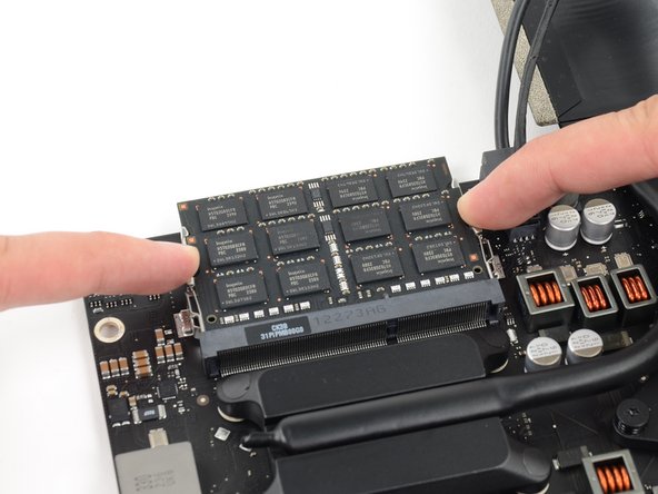 Image 2/3: Grab the top left and right corners of the RAM module and carefully pull it straight out of its socket.