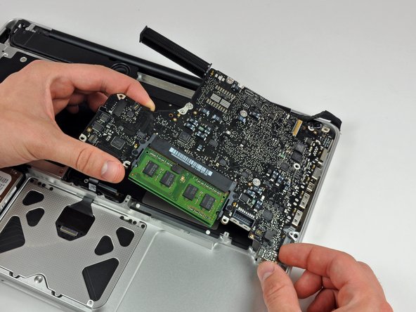Image 1/2: Pull the logic board away from the side of the upper case and remove it, minding the DC-in board that may get caught.
