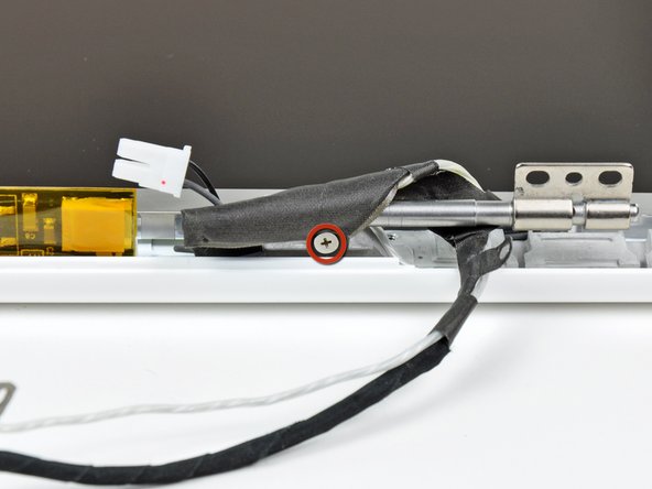 Remove the single 3.2 mm Phillips screw securing the display data cable to the right clutch hinge.