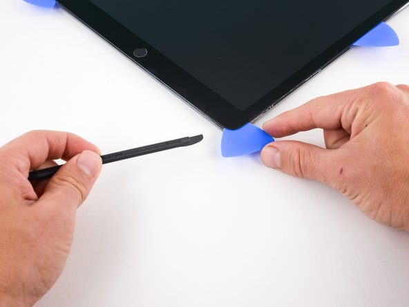 Insert a pick in the lower right corner of the iPad where you slid the blade through.
