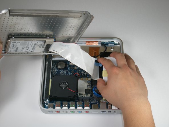 Image 1/2: During reassembly, make sure the hard drive data cable is firmly seated in its socket on the logic board; otherwise, during boot-up you will see a flashing question mark "?".