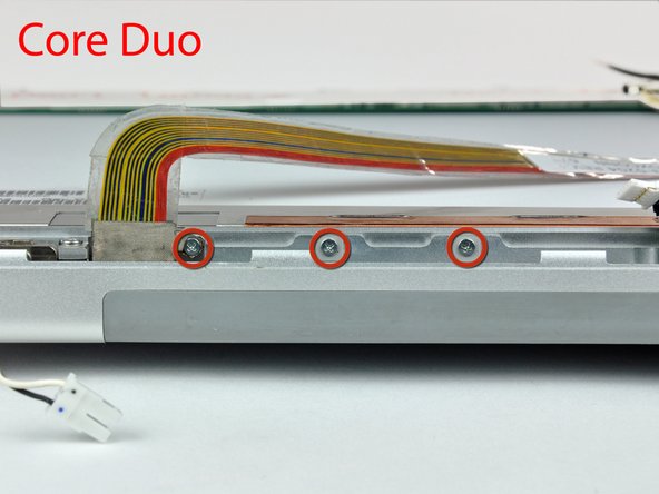 Image 1/2: If you have a Core 2 Duo Model A1211 machine, refer to picture 2 and remove two Phillips screws connecting the clutch assembly to the lower edge of the front display bezel near the display data cable.