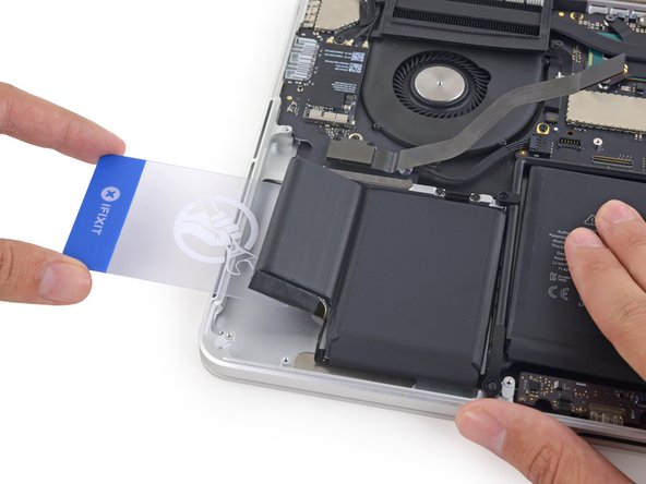 Use a second plastic card to separate the two leftmost battery cells from the upper case.