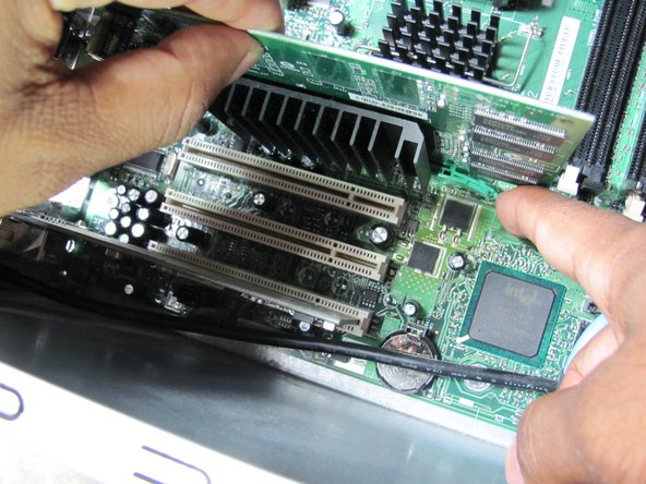 Image 1/1: Push down on the green clip located by the bottom right corner of the video card while simultaneously pulling the card up with your other hand.