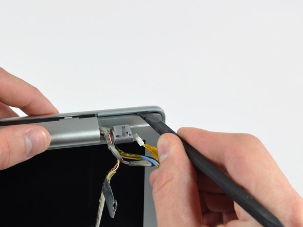 Image 1/2: Rotate your spudger toward the rear bezel to separate it from the front bezel.