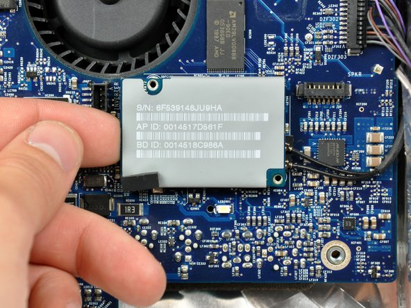 Image 2/2: Lift the AirPort/Bluetooth board from its left edge only. Trying to lift from its right edge may break the connector off the logic board.