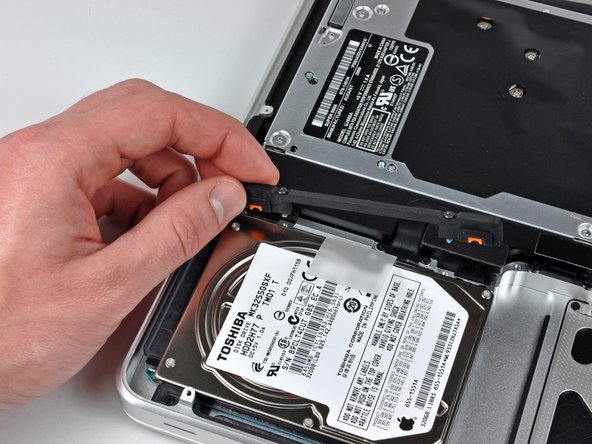 Image 2/2: Lift the the retaining bracket out of the upper case.