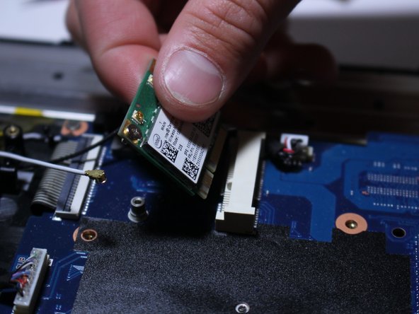 Now grab the Wi-Fi card and slowly pull it up and outward as shown in the photos.