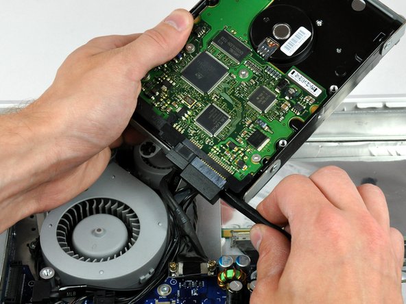 Image 1/2: Twist the spudger counter-clockwise to slightly separate the SATA power cable connector from its socket on the hard drive.