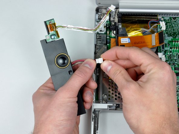 Image 2/2: Lift the left speaker housing from the lower case and disconnect the microphone/speaker connector.