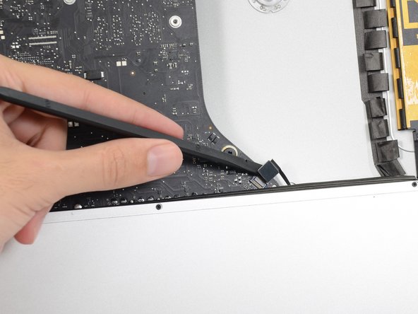 Image 2/3: Push the cable slightly to the right to clear it for the removal of the logic board.