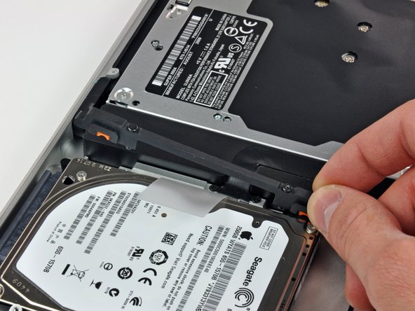 Image 2/2: Lift the the retaining bracket out of the upper case.