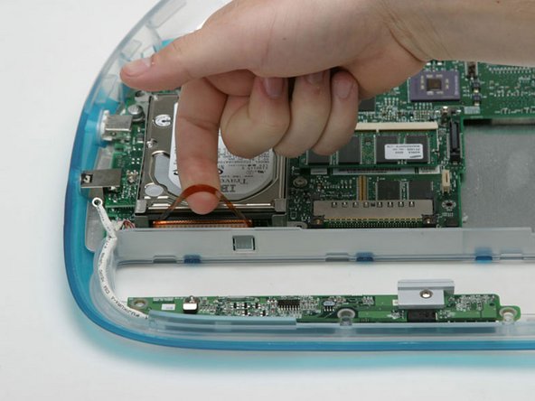 Image 1/1: Lift the hard drive, with metal bracket attached, from the logic board.