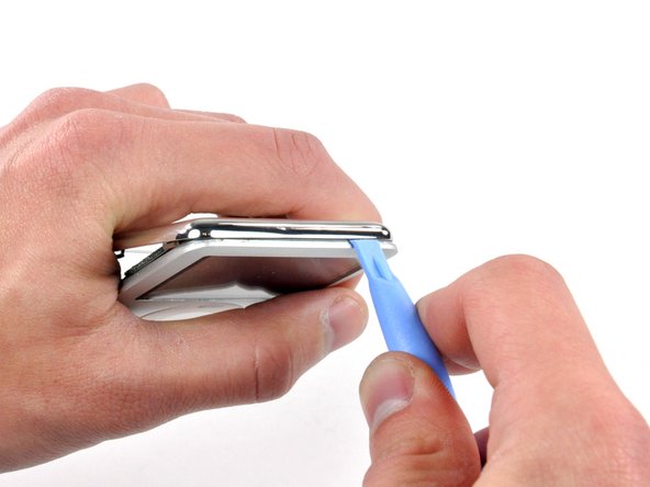 Image 1/1: After ensuring all tabs are free, separate the two halves of the iPod.