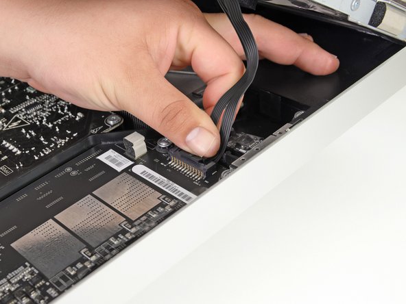 Image 1/1: Disconnect the LED backlight driver cable with your hand by pressing the tab down and sliding it towards the bottom of the display.