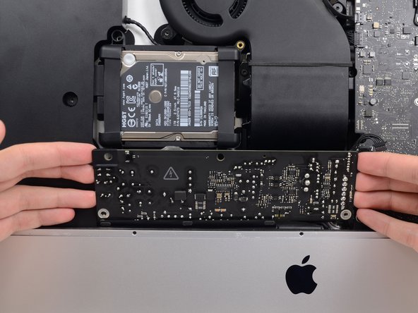 Image 1/3: Rotate the power supply counterclockwise, lifting the right side up about an inch higher than the left.