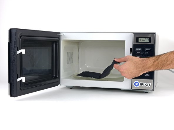 Remove the iOpener from the microwave, holding it by one of the two flat ends to avoid the hot center.