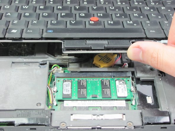 Image 1/2: Lift the keyboard until you are able to see the wire connection