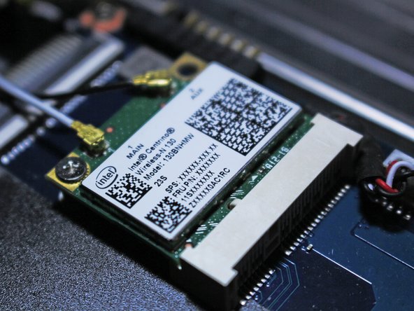 Insert your new Wi-Fi card and screw it into place with your screwdriver.