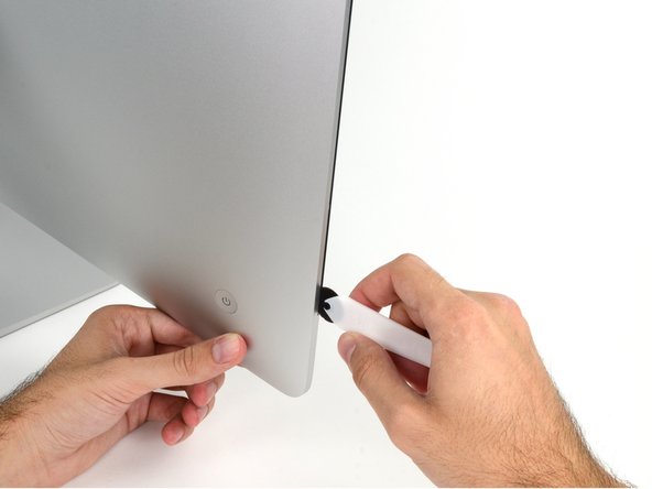 Image 1/2: The hub on the iMac Opening Tool will keep you from pushing the wheel in too far. If using a different tool, insert no more than 3/8" into the display. Otherwise, you risk severing antenna cables and causing serious damage.