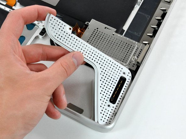 Image 2/2: Lift the battery connector cover out of the upper case.