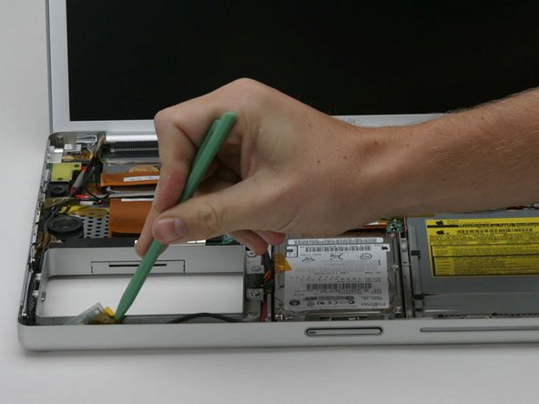 Image 1/1: Use a spudger to pry the bluetooth board from the gap between the battery housing and front of the lower case.