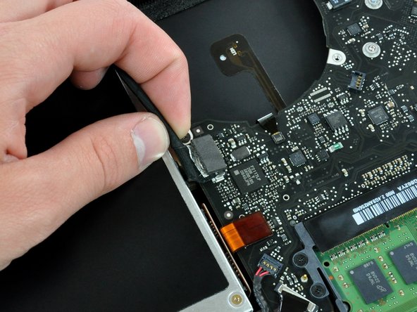 Image 1/1: Disconnect the camera cable by pulling the male end out of its socket, parallel to the logic board, '''do not''' lift it upwards.