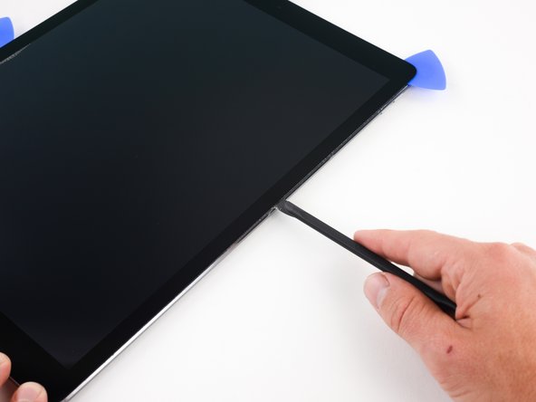 Continue using the halberd spudger to cut away the adhesive holding the display assembly in place, stopping at the middle of the right edge.